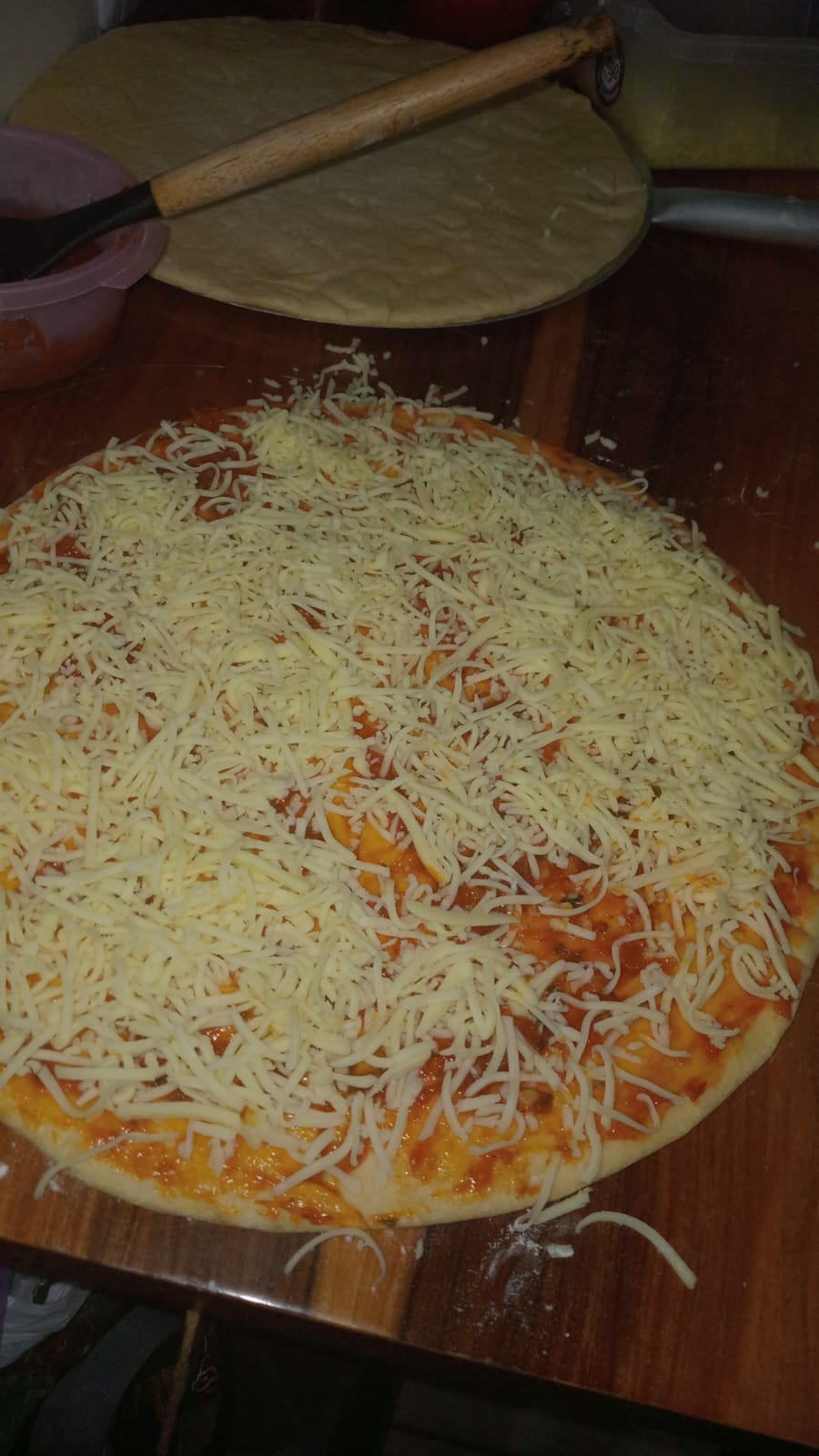 Pizza em preparo com molho e queijo antes de assar